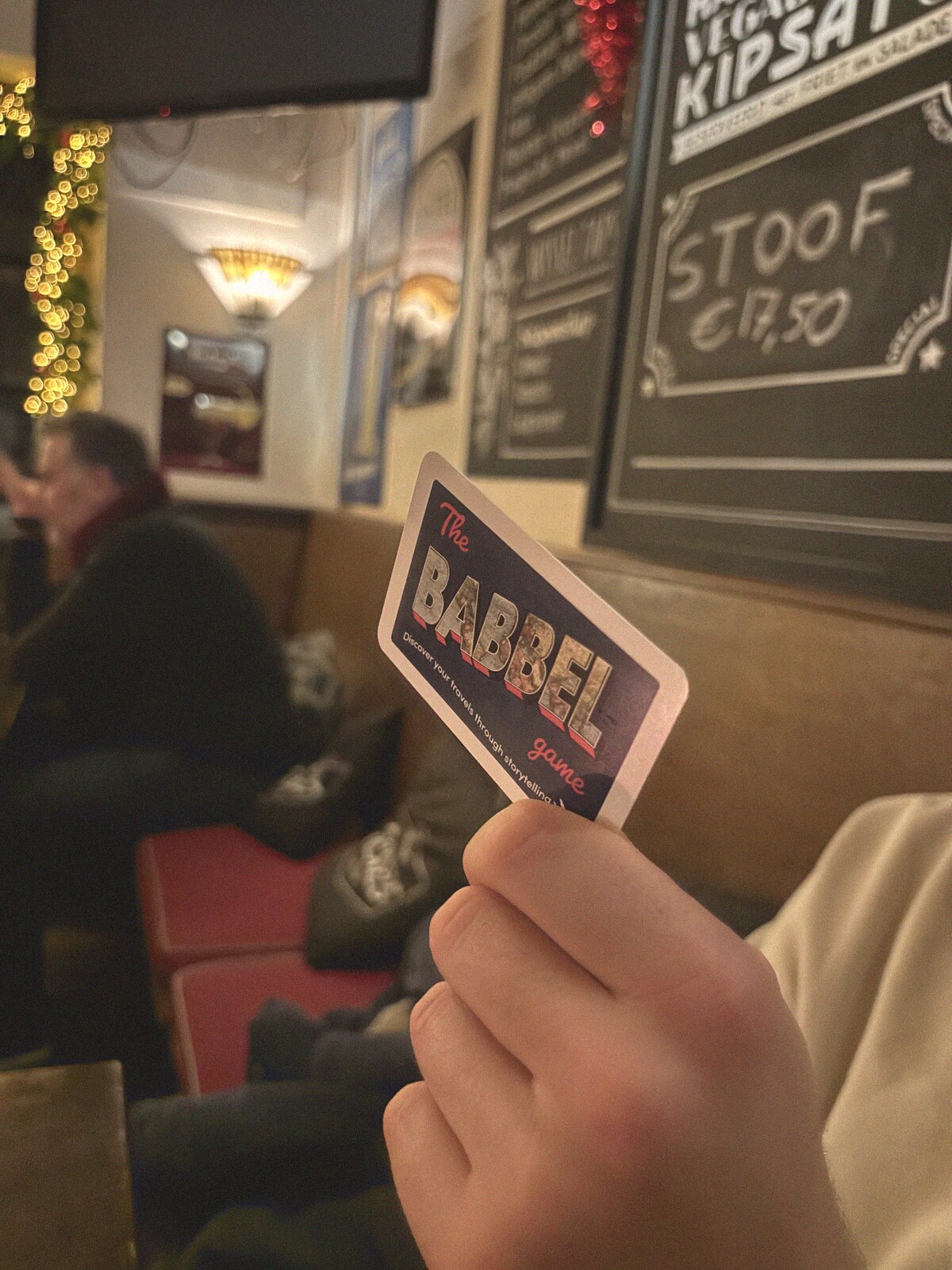 Holding a Babbel card in a warm, busy bar
