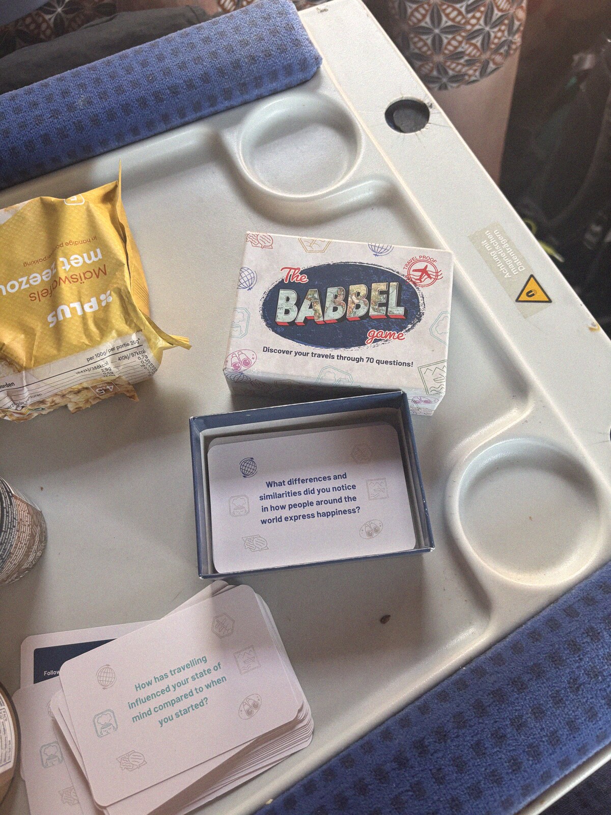 Babbel cards on a train tray table next to a snack