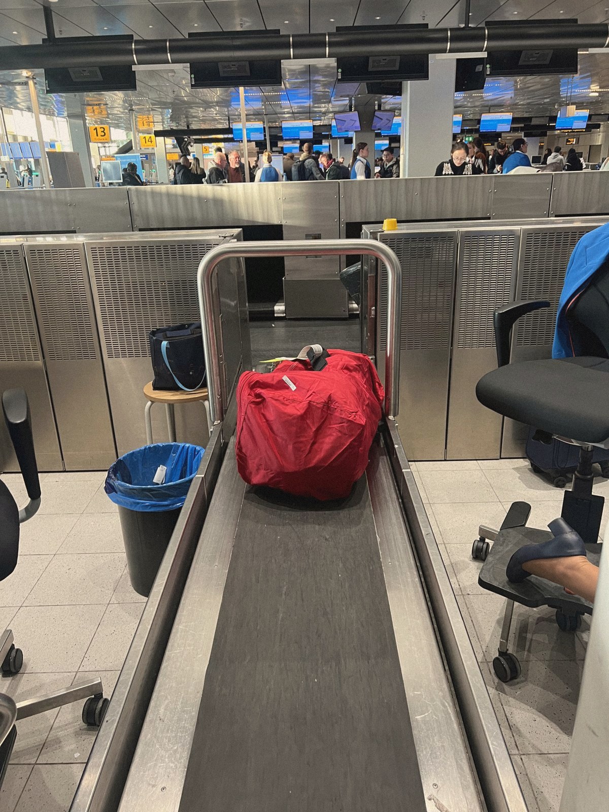 A red backpack on the check-in belt at the airport